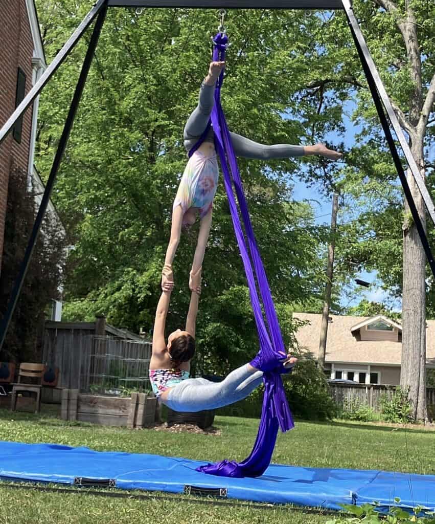 Neighborhood aerialists Sadie and Violeta, doing an aerial silks performance at the Garden Tour on April 28.  The silks are suspended from Violeta’s rig, temporarily set up in Sadie’s yard.